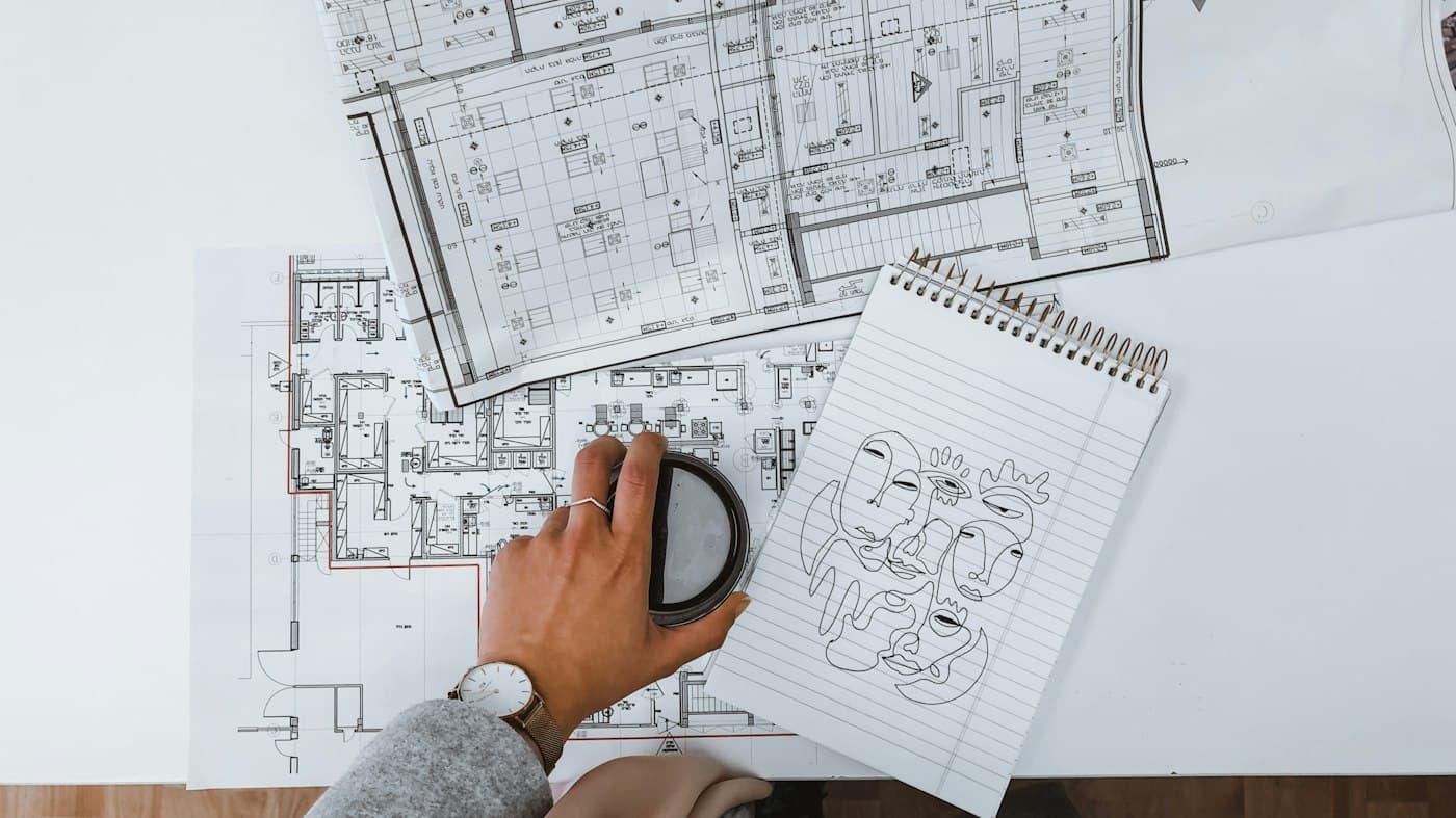 Persona revisando un plano de distribución sobre una mesa
