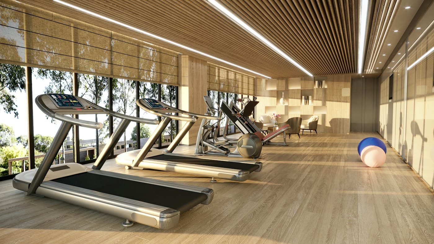 Sala de cardio con trotadoras frente a ventanales y techo de madera